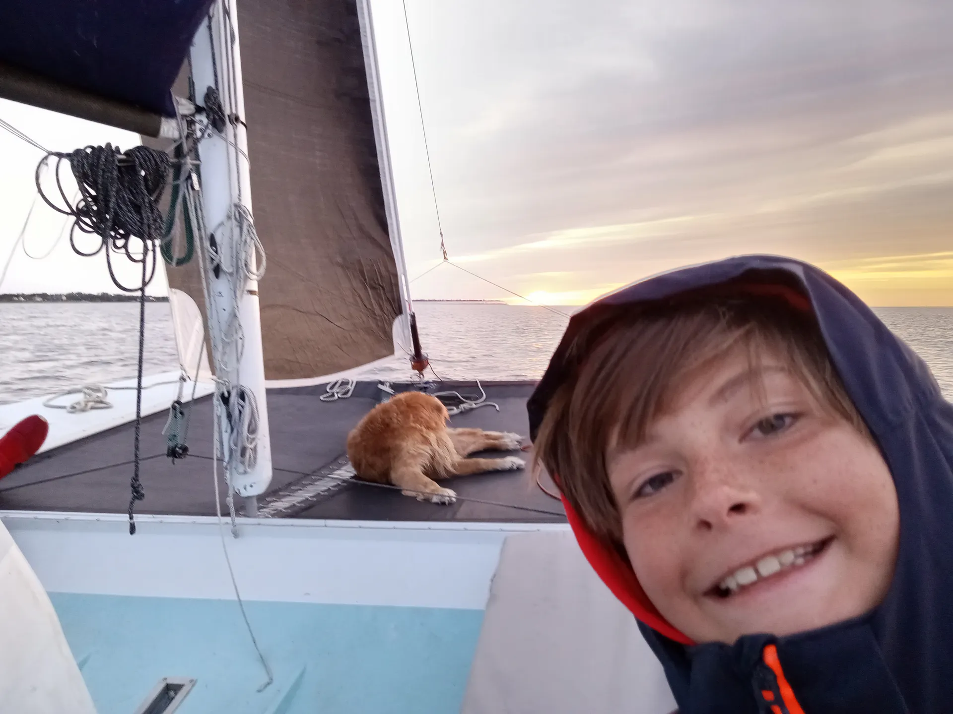 Kid and dog aboard at sunset