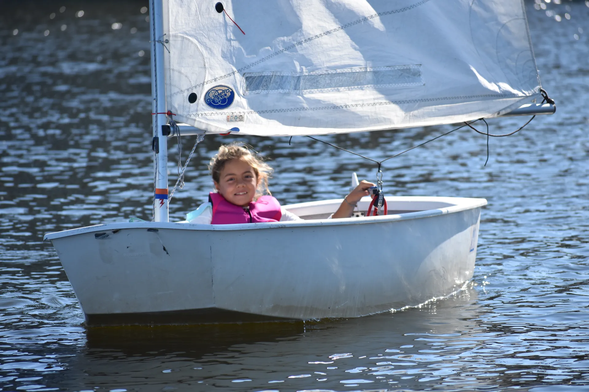 Junior sailor in her Optimist dinghy
