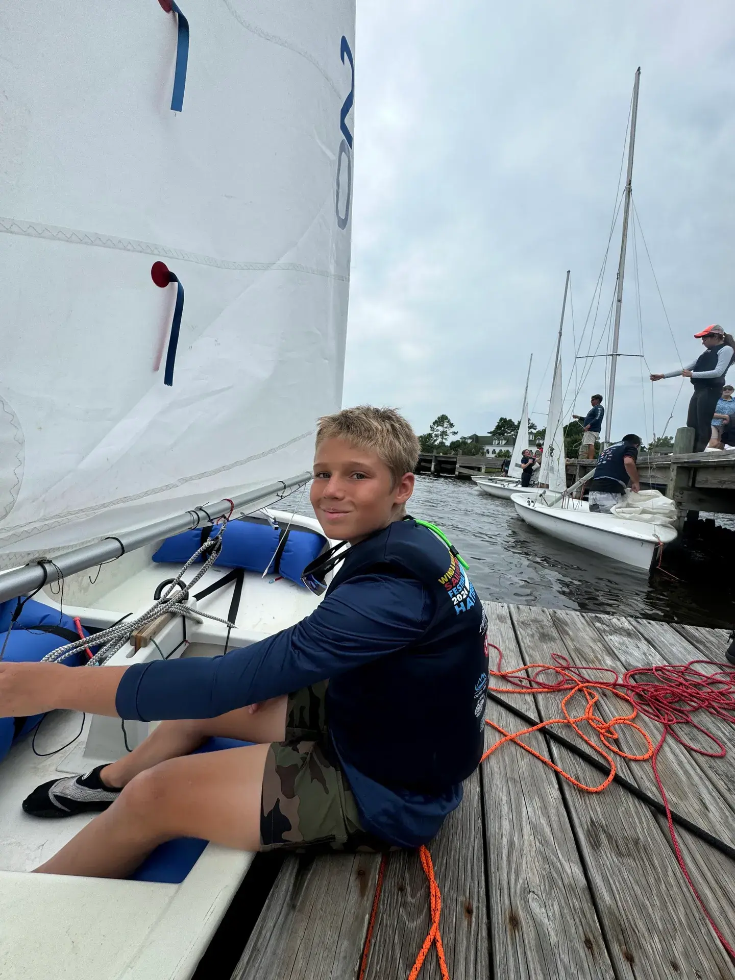 Young sailor rigging at the dock